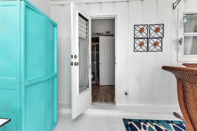 hallway featuring wooden walls