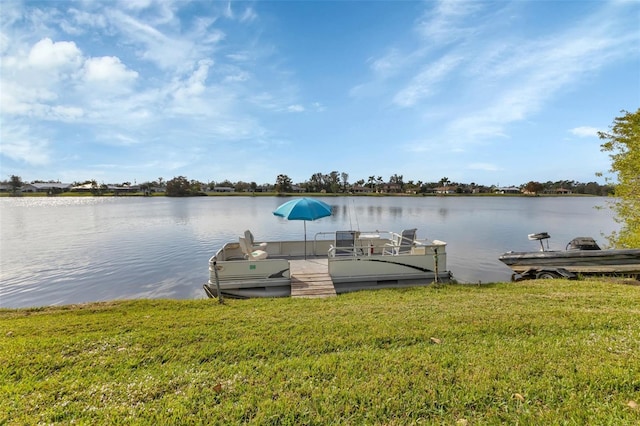 dock area featuring a lawn and a water view