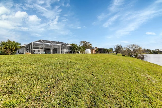 view of yard with glass enclosure and a water view