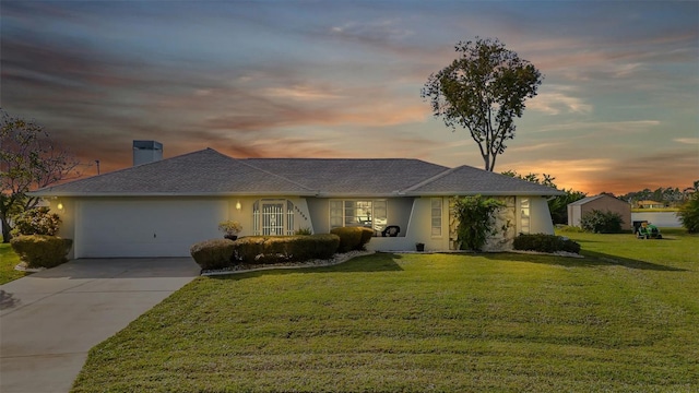 ranch-style home with a garage and a lawn