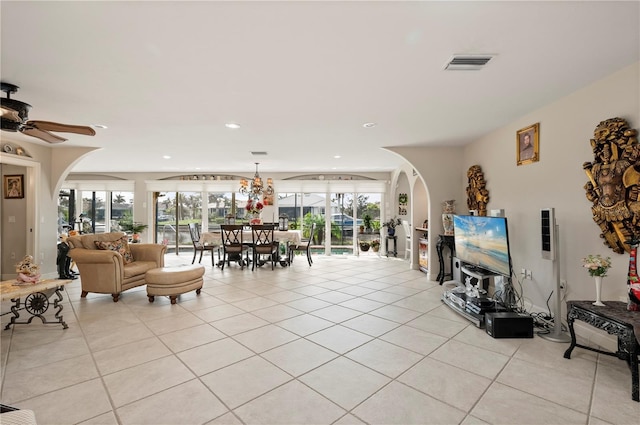 tiled living room with ceiling fan and a wealth of natural light