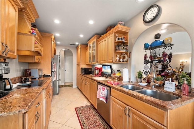 kitchen with sink, light tile patterned flooring, light stone counters, and appliances with stainless steel finishes