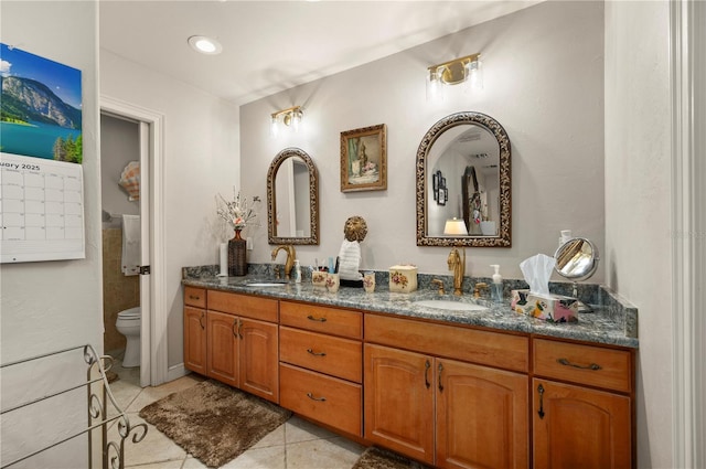 bathroom with toilet, vanity, and tile patterned flooring