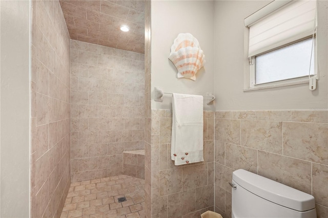 bathroom with tile walls, toilet, and tiled shower