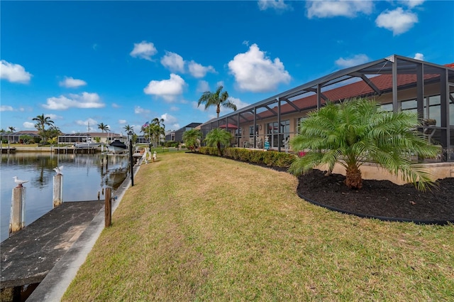 view of yard featuring a water view, glass enclosure, and a boat dock