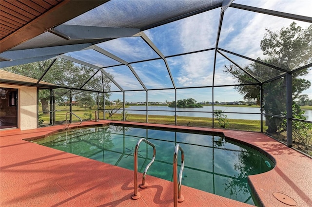 view of pool featuring a patio, a water view, and glass enclosure