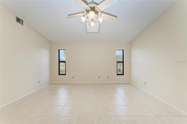 tiled spare room featuring vaulted ceiling, a healthy amount of sunlight, and ceiling fan