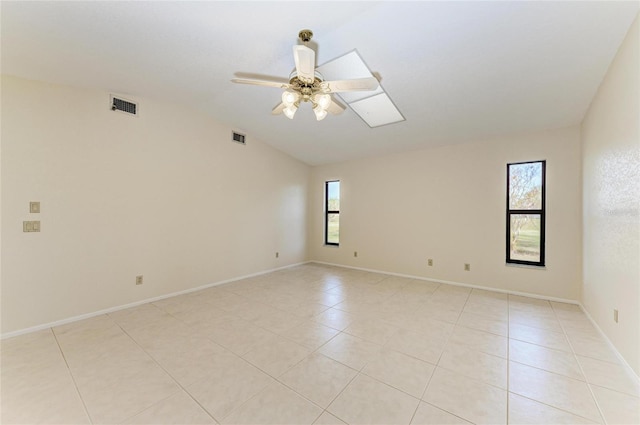 tiled spare room with vaulted ceiling and ceiling fan