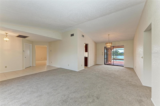 carpeted empty room featuring lofted ceiling, a notable chandelier, and a textured ceiling