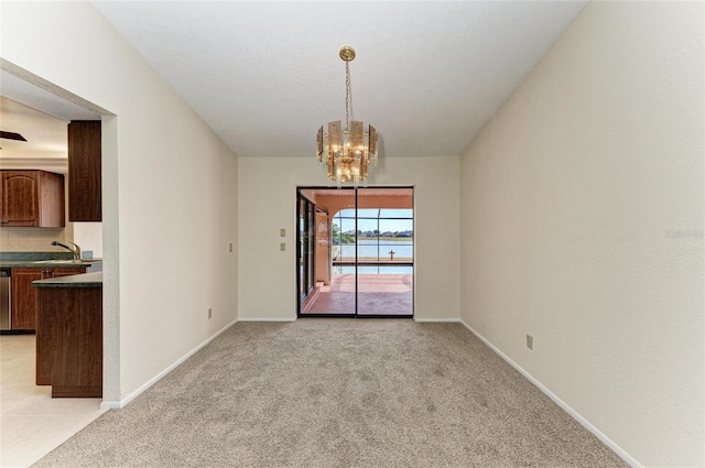 unfurnished dining area featuring an inviting chandelier, sink, and light carpet