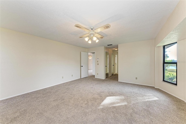 carpeted spare room with ceiling fan and a textured ceiling