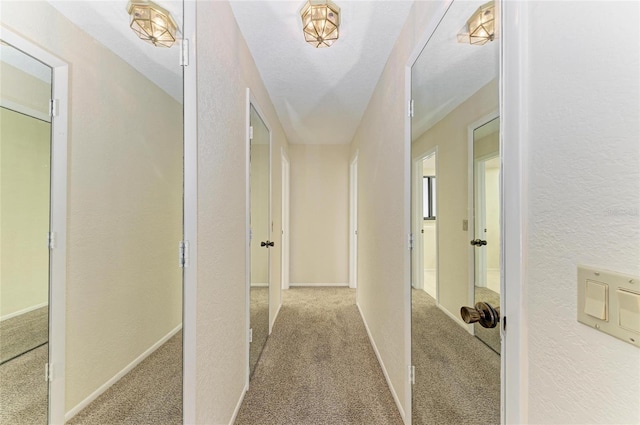corridor featuring a textured wall and carpet flooring