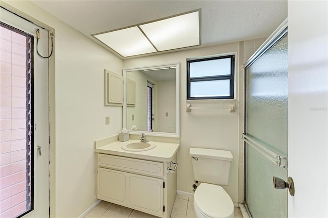 bathroom with toilet, vanity, tile patterned floors, and a stall shower