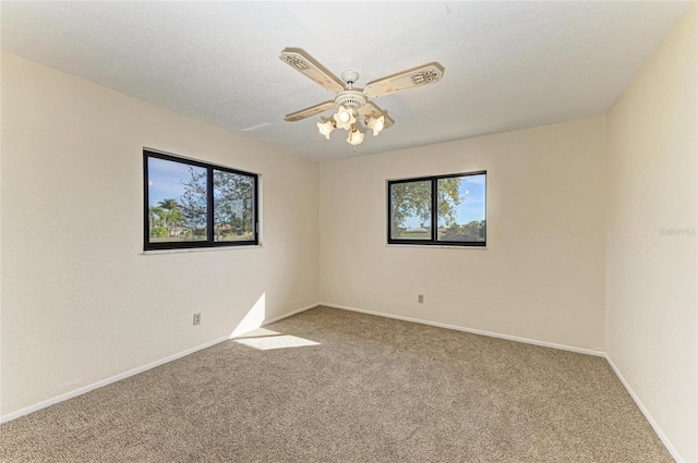 unfurnished room featuring a ceiling fan, baseboards, carpet, and a healthy amount of sunlight