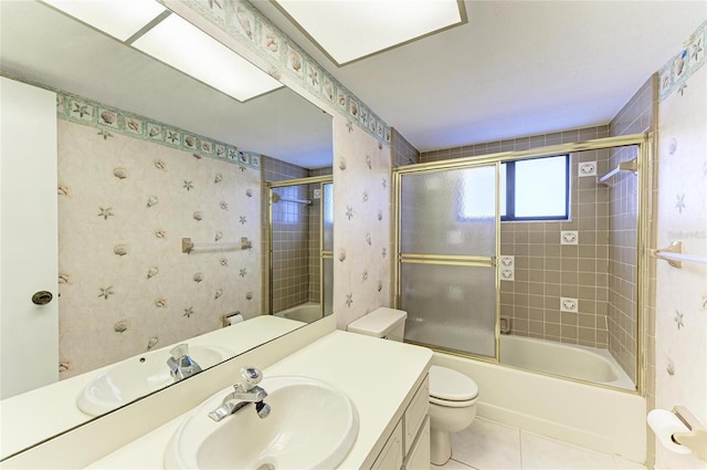 bathroom featuring wallpapered walls, tile patterned flooring, toilet, vanity, and bath / shower combo with glass door