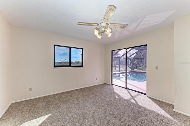 empty room featuring carpet, a ceiling fan, and baseboards