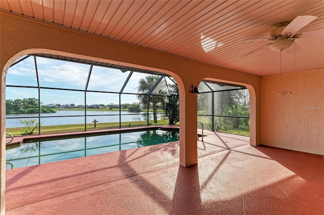 outdoor pool with a ceiling fan, a lanai, a patio, and a water view