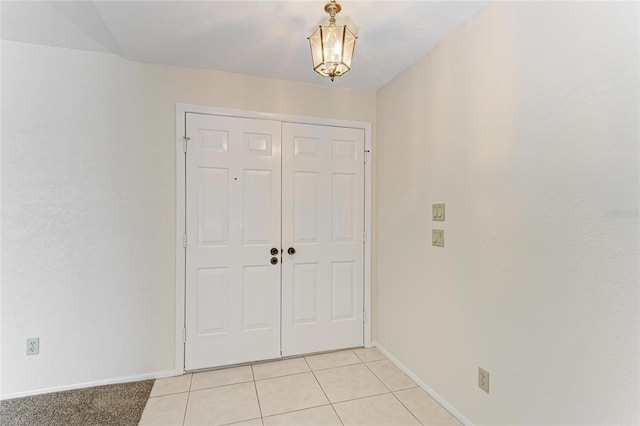 entryway with baseboards and light tile patterned floors