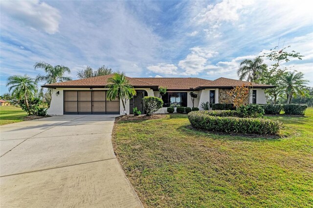 ranch-style home featuring a garage, concrete driveway, a front yard, and stucco siding