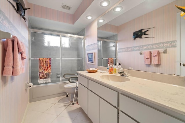 full bathroom featuring vanity, combined bath / shower with glass door, tile patterned floors, and toilet