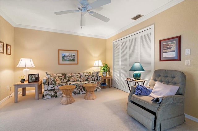 living room featuring ornamental molding, ceiling fan, and carpet