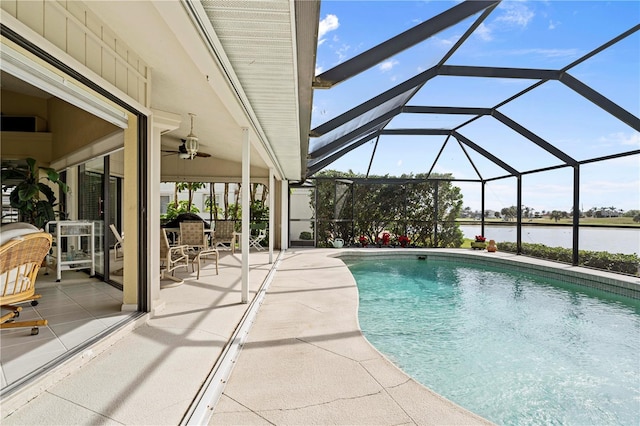 view of swimming pool with ceiling fan, a water view, glass enclosure, and a patio area