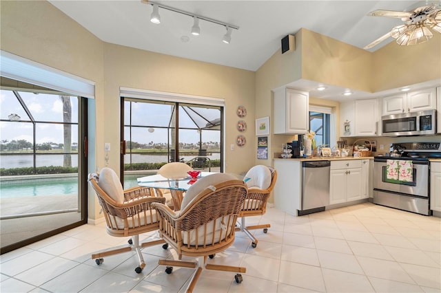 kitchen featuring a water view, appliances with stainless steel finishes, a healthy amount of sunlight, and white cabinets