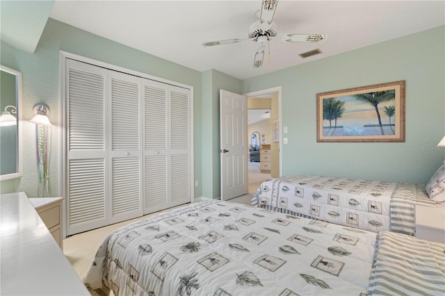 carpeted bedroom featuring ceiling fan and a closet