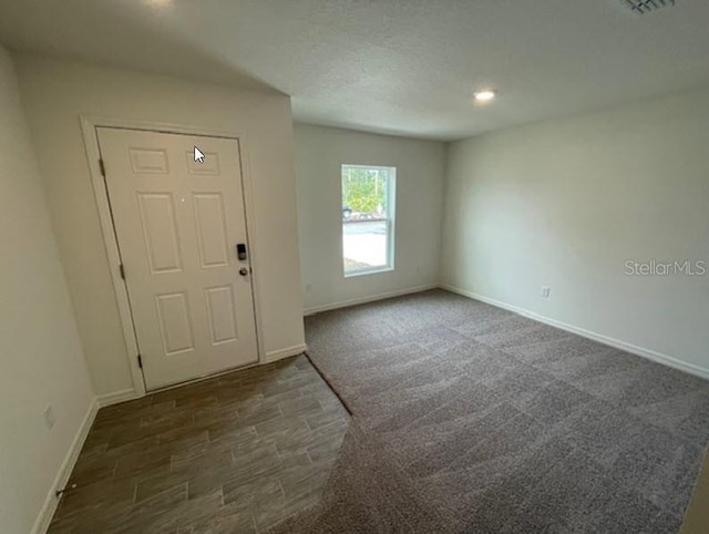 entrance foyer with dark hardwood / wood-style floors and a textured ceiling