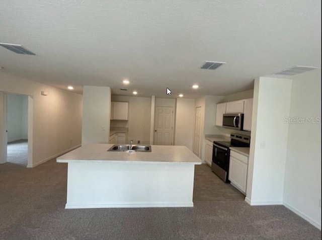 kitchen with sink, stainless steel appliances, white cabinets, and a center island with sink