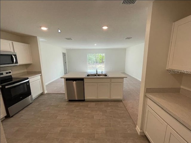 kitchen featuring white cabinetry, appliances with stainless steel finishes, sink, and kitchen peninsula