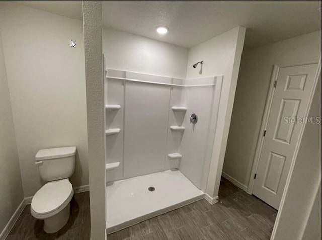 bathroom with wood-type flooring, toilet, and walk in shower