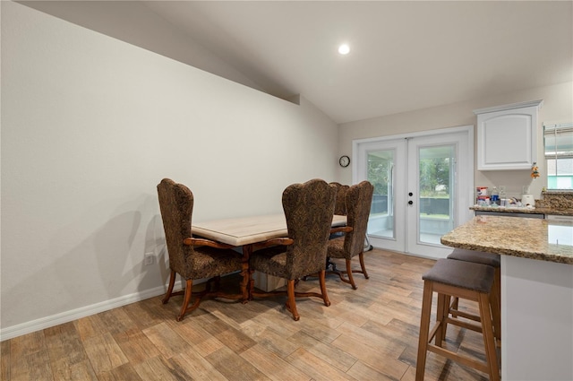 dining area featuring lofted ceiling and french doors