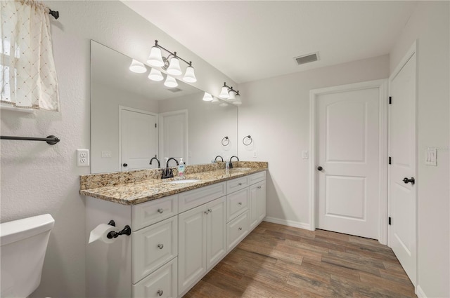 bathroom with vanity, toilet, and hardwood / wood-style floors