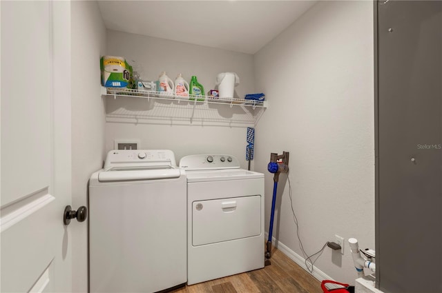 clothes washing area featuring hardwood / wood-style flooring and washing machine and clothes dryer