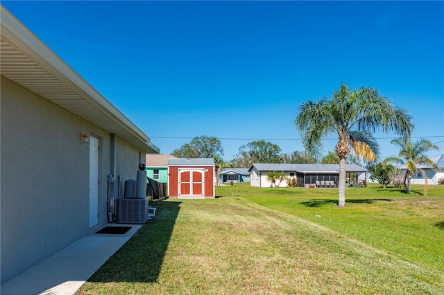 view of yard with central air condition unit and a storage unit