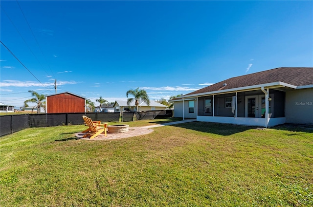 view of yard with an outdoor fire pit and a sunroom