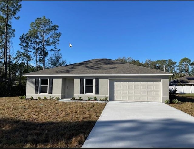 ranch-style house featuring a garage and a front lawn