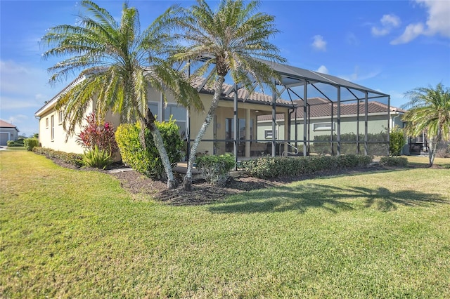 back of property featuring a yard and glass enclosure