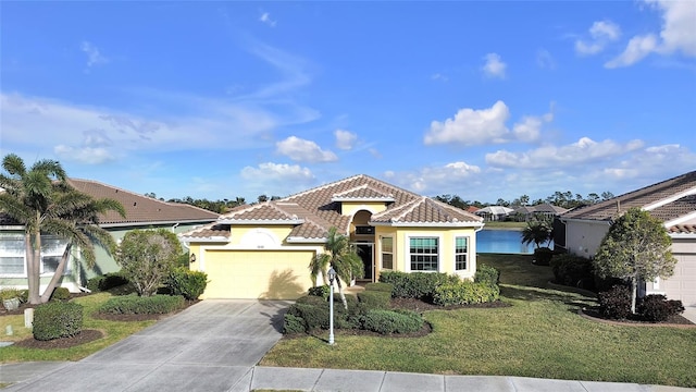 mediterranean / spanish house with a garage, a front lawn, and a water view