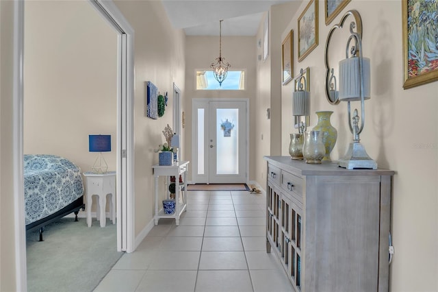 carpeted entryway featuring an inviting chandelier