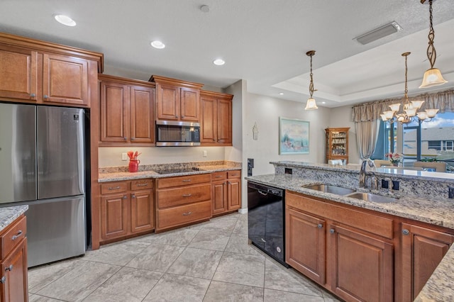 kitchen with black appliances, sink, pendant lighting, light stone counters, and a tray ceiling