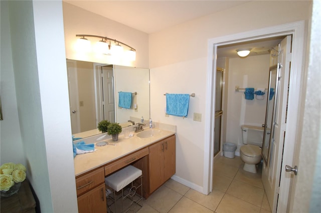 bathroom with vanity, tile patterned floors, toilet, and walk in shower