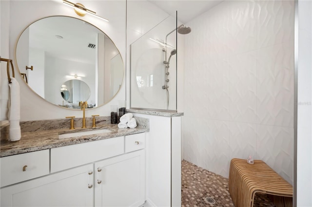 bathroom featuring tile walls, walk in shower, and vanity