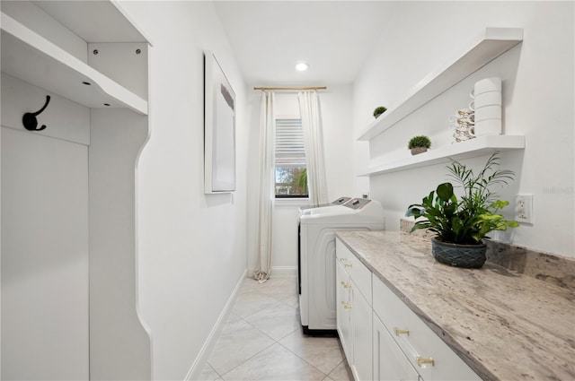 laundry room featuring cabinets, light tile patterned floors, and washing machine and dryer