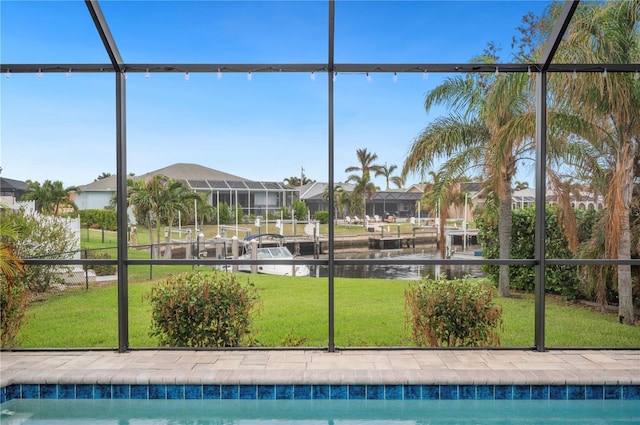 view of pool with a water view, a lawn, and a lanai