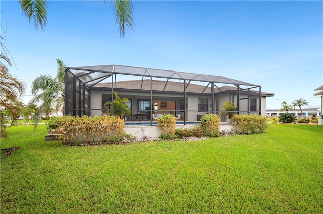 back of property featuring a lanai and a lawn