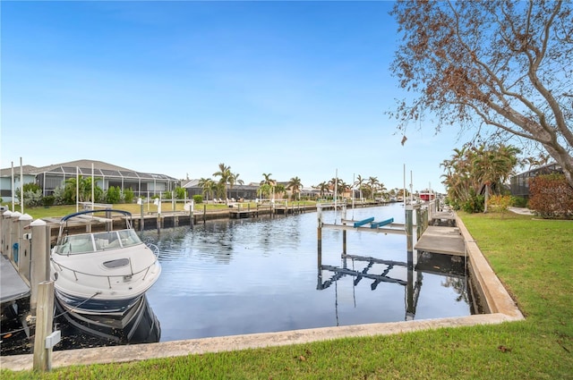 dock area with a lawn and a water view