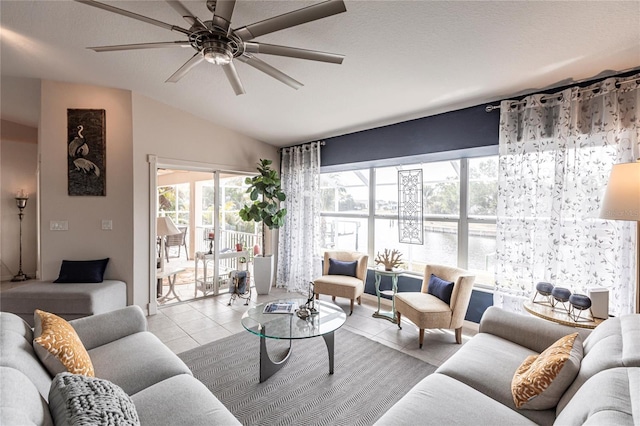 tiled living room featuring ceiling fan, vaulted ceiling, a textured ceiling, and a wealth of natural light