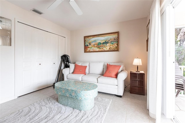 living room featuring a wealth of natural light, light tile patterned floors, and ceiling fan